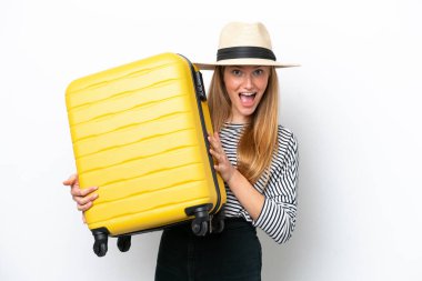 Beyaz arka planda izole genç beyaz kadın seyahat valiziyle ve sürpriz