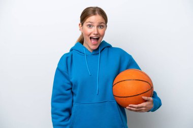 Basketbol oynayan beyaz tenli genç bir kadın, beyaz arka planda izole edilmiş ve yüz ifadesi şaşırtıcıydı.
