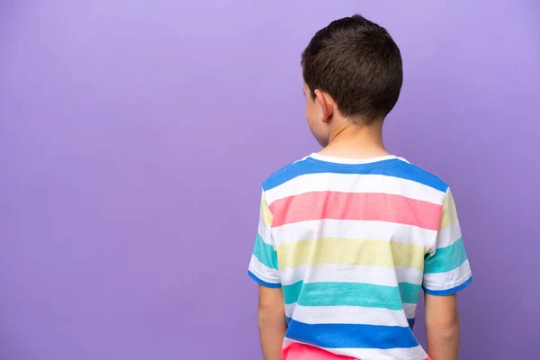 小男孩被紫色背景隔离 背向后看 — 图库照片
