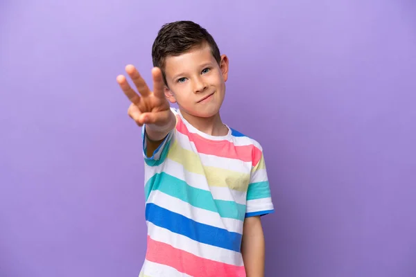 紫色の背景に孤立した小さな男の子幸せと指で3を数える — ストック写真