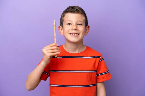 紫色の背景に孤立した小さな男の子の歯をブラッシング多くの笑顔 — ストック写真