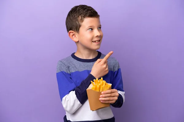 Menino Segurando Chips Fritos Isolados Fundo Roxo Apontando Para Uma — Fotografia de Stock