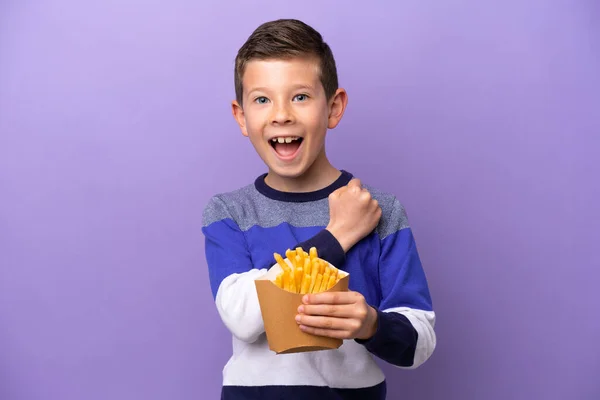 Маленький Хлопчик Тримає Смажені Чіпси Ізольовані Фіолетовому Фоні Відзначаючи Перемогу — стокове фото