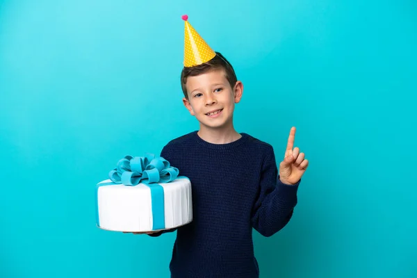 Ragazzino Tenendo Torta Compleanno Isolato Sfondo Blu Mostrando Alzando Dito — Foto Stock