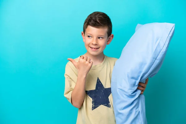 Malý Chlapec Pyžamu Izolované Modrém Pozadí Ukazuje Stranu Prezentovat Produkt — Stock fotografie