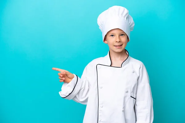 Piccolo Chef Ragazzo Isolato Sfondo Blu Puntando Dito Verso Lato — Foto Stock