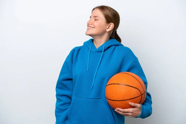年轻的高加索女子在白人背景下打篮球 侧身大笑 — 图库照片