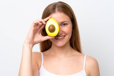 Beyaz arka planda izole edilmiş beyaz bir kadın elinde bir avokado tutarken gülümsüyor. Portreyi kapat