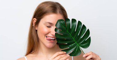 Beyaz arka planda izole edilmiş beyaz bir kadın elinde mutlu bir ifadeyle bir palmiye yaprağı tutuyor. Portreyi kapat