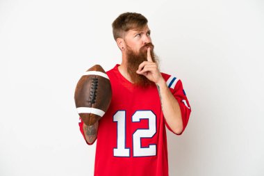 Beyaz arka planda ragbi oynayan Kafkas 'lı genç bir adam şüpheli bir şekilde yukarı bakıyor.