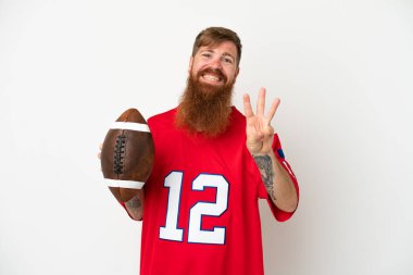 Beyaz arka planda ragbi oynayan Kafkasyalı genç adam mutlu ve parmaklarıyla üçe kadar sayıyor.