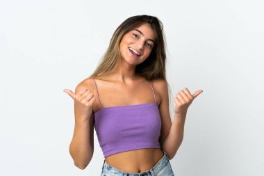 Beyaz arka planda izole edilmiş beyaz bir kadın. Baş parmakları havada ve gülümsüyor.