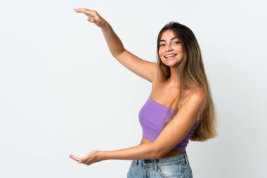 Beyaz arka planda izole edilmiş genç beyaz bir kadın ilan vermek için kopyalama alanı tutuyor.