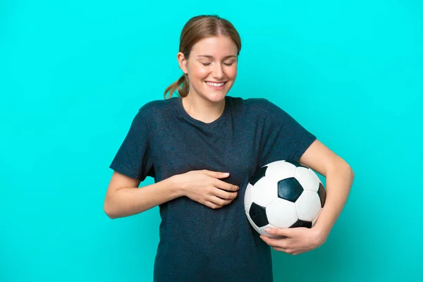 年轻的足球女运动员被蓝色背景隔离 面带微笑 — 图库照片