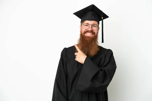 Jovem Universitário Graduado Homem Avermelhado Isolado Fundo Branco Apontando Para — Fotografia de Stock