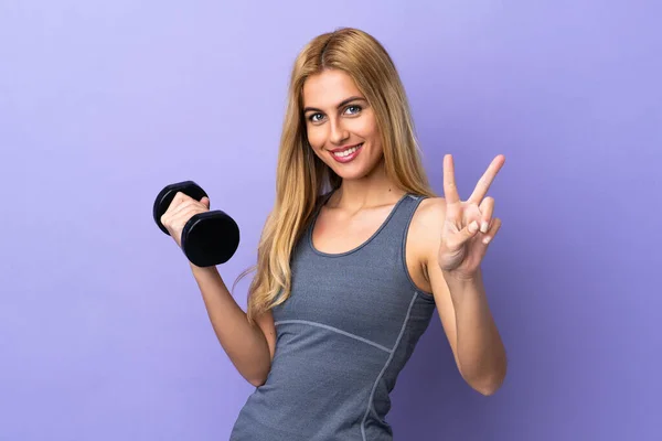 Young Blonde Sport Woman Making Weightlifting Isolated Purple Background Smiling — Stock Photo, Image