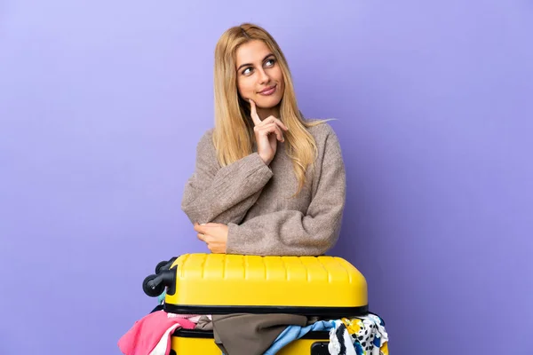 Молодая Уругвайская Блондинка Чемоданом Набитым Одеждой Над Изолированной Фиолетовой Стеной — стоковое фото