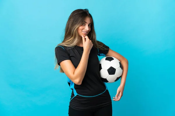 Молодая Женщина Футболист Изолированы Синем Фоне Глядя Сторону Улыбаясь — стоковое фото