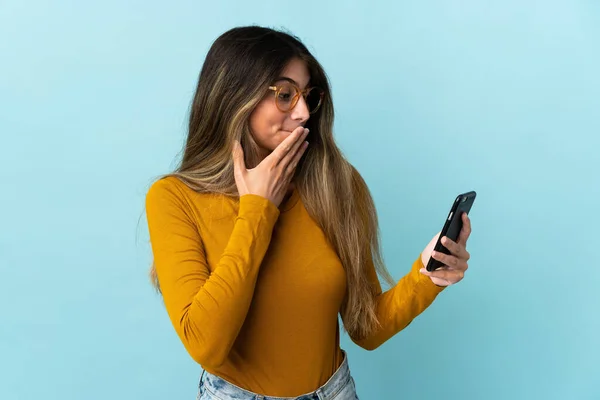 Giovane Donna Caucasica Utilizzando Telefono Cellulare Isolato Sfondo Blu Con — Foto Stock