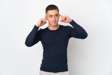 Beyaz arka planda soyutlanmış genç beyaz bir adamın şüpheleri ve düşünceleri var.