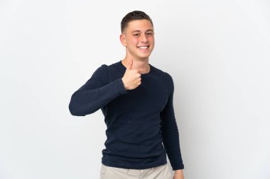 Beyaz arka planda izole edilmiş genç beyaz bir adam baş parmak hareketi yapıyor.