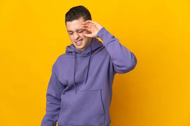 Sarı arka planda izole edilmiş, yorgun ve hasta bir ifadeyle genç beyaz bir adam.