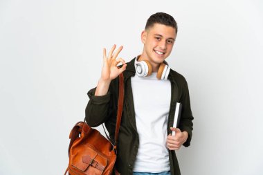 Beyaz arka planda izole genç beyaz öğrenci parmaklarıyla tamam işareti gösteriyor.