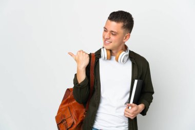 Beyaz arka planda izole genç beyaz öğrenci bir ürün sunmak için kenarı işaret ediyor