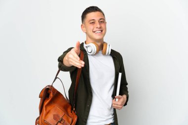 Beyaz arka planda izole genç beyaz öğrenci iyi bir anlaşma için el sıkışıyor
