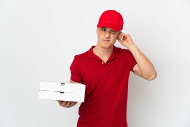 İş üniformalı bir pizzacı beyaz arka planda izole edilmiş pizza kutularını topluyor hayal kırıklığına uğramış ve kulaklarını kapatıyor.
