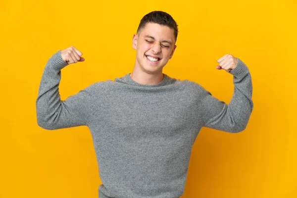 Young Caucasian Man Isolated Yellow Background Doing Strong Gesture — Stock Photo, Image