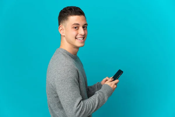 Junger Kaukasischer Mann Isoliert Auf Blauem Hintergrund Sendet Eine Nachricht — Stockfoto