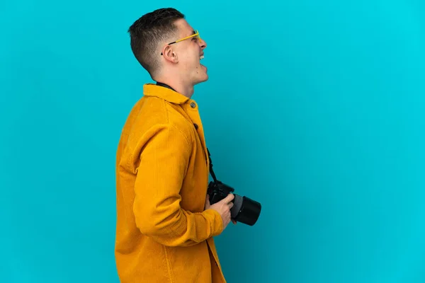 Young Caucasian Photographer Man Isolated Blue Background Laughing Lateral Position — Stock Photo, Image