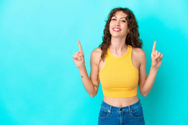 Jovem Com Cabelo Encaracolado Isolado Fundo Azul Apontando Para Uma — Fotografia de Stock