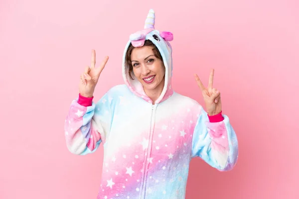 Jovem Caucasiana Com Pijama Unicórnio Isolado Fundo Rosa Mostrando Sinal — Fotografia de Stock