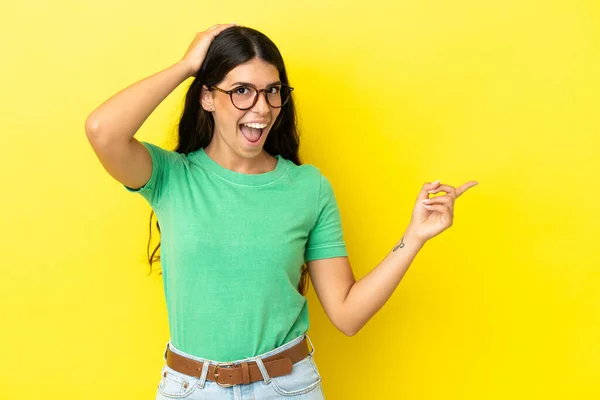 Young Caucasian Woman Isolated Yellow Background Surprised Pointing Finger Side — Stock Photo, Image