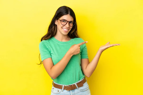 Mujer Caucásica Joven Aislada Sobre Fondo Amarillo Sosteniendo Espacio Copia — Foto de Stock