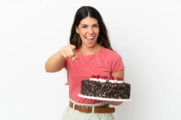 若いですCaucasian女性保持誕生日ケーキ隔離上の白い背景驚きと指摘フロント — ストック写真