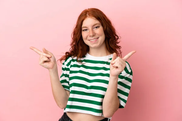 ティーンRedhead女の子上の隔離されたピンクバックグランドポインティング指へザLateralsと幸せな — ストック写真