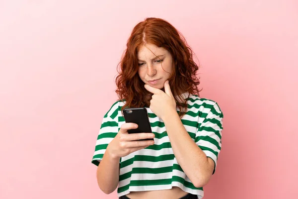 Tiener Roodharige Meisje Geïsoleerde Roze Achtergrond Denken Het Verzenden Van — Stockfoto