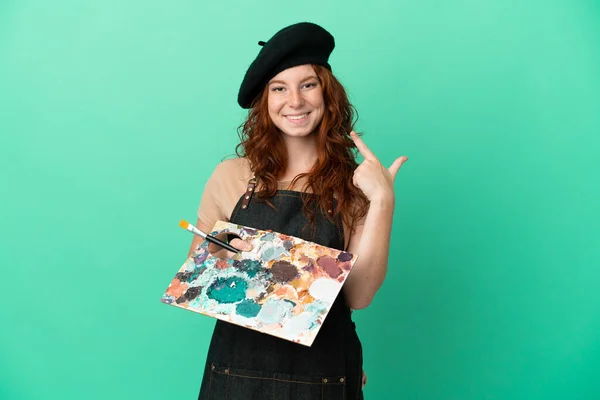 Nastoletni Rudowłosy Artysta Trzymając Paletę Odizolowanych Zielonym Tle Dając Kciuki — Zdjęcie stockowe