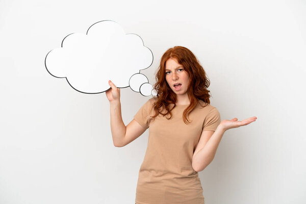 Teenager redhead girl isolated on white background holding a thinking speech bubble and with sad expression