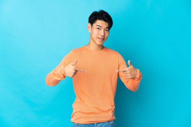 Mavi arka planda kendini beğenmiş ve gururlu genç bir Çinli.