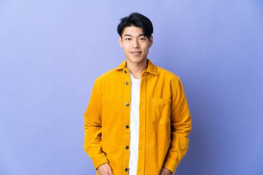 Mor arka planda yalnız yaşayan genç bir Çinli gülüyor.