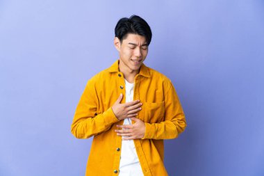 Mor arka planda izole edilmiş genç bir Çinli. Çok gülümsüyor.