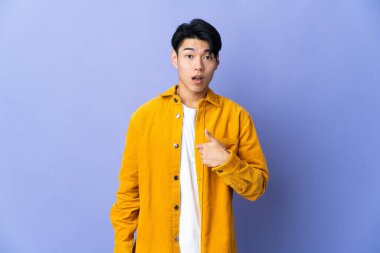 Mor arka planda izole edilmiş genç bir Çinli kendini işaret ediyor.