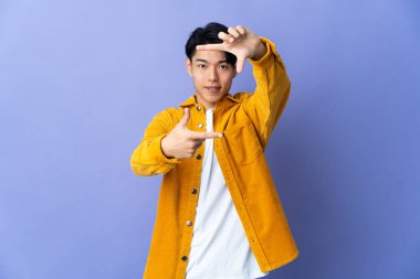 Mor arka planda yüzü odaklayan genç bir Çinli. Çerçeve sembolü