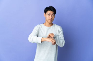 Mor arka planda izole edilmiş genç bir Çinli geç kalma hareketi yapıyor.