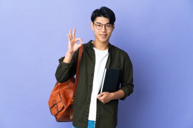 Mor arka planda izole edilmiş genç bayan parmaklarıyla işaret veriyor.