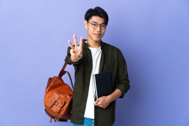 Mor arka planda izole genç bayan mutlu ve parmaklarıyla üçe kadar sayıyor.